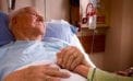 Old man lying in hospital bed holding daugher What happens when a hospice rejects medical assistance in dying?