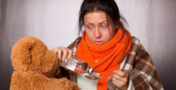 Young woman taking flu medication Antibiotics no cure for colds or flu