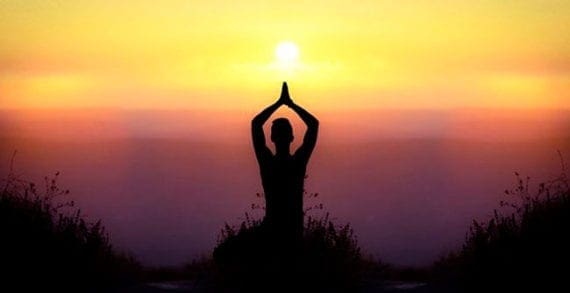 Practicing yoga as the sun falls How to enjoy being idle without feeling guilty